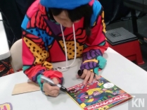 Chiaki autographing her English translated artbook for fans